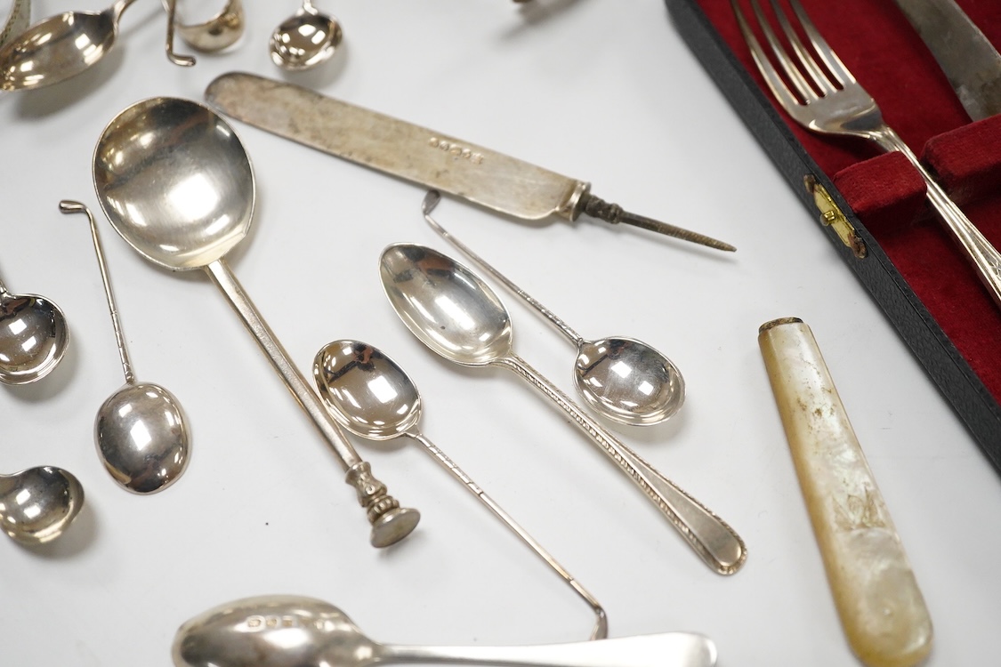 A small quantity of assorted small silver and plated flatware, a small silver stand, a silver napkin ring and a pair of modern silver mounted dwarf candlesticks.
